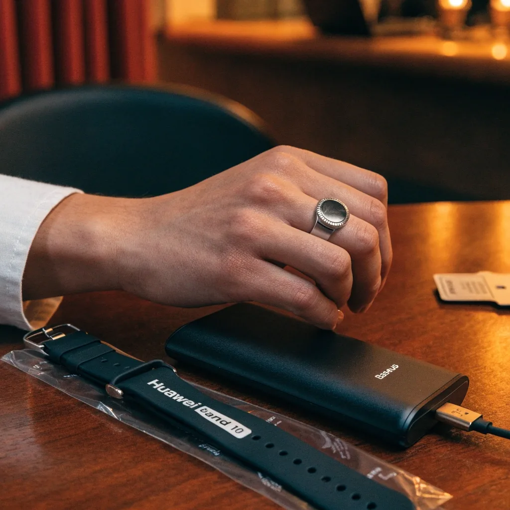Cargador inalámbrico y fundas para celular sobre una superficie oscura